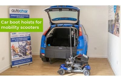 Car boot hoist listing a mobility scooter