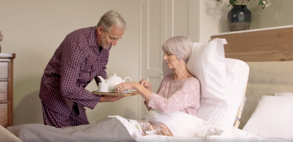 man serving a woman in adjustable bed