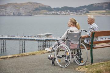 pink wheelchair by seaside