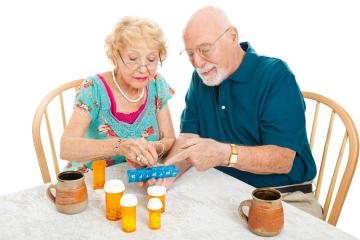 couple organising pills into a weekly reminder box