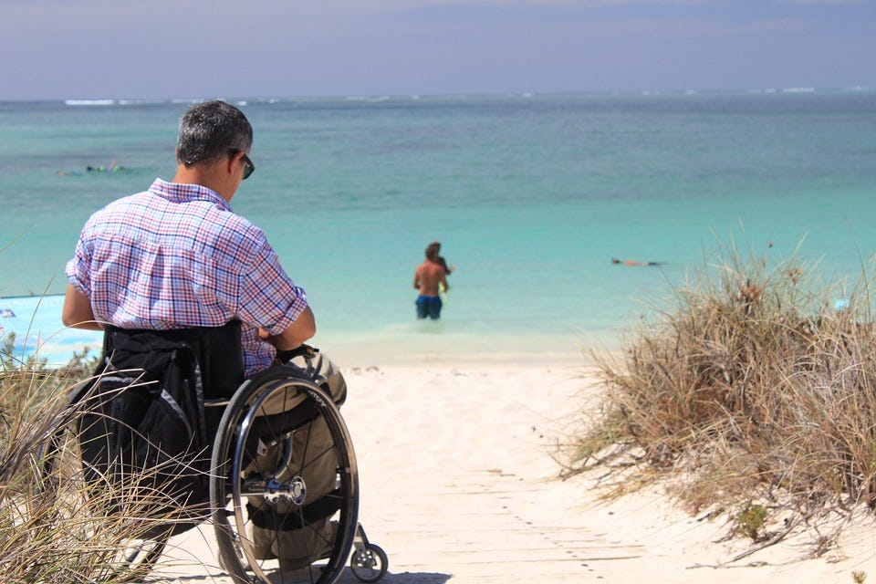 man in wheelchair on the beach