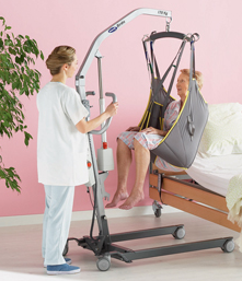 nurse moving elderly lady in a hoist