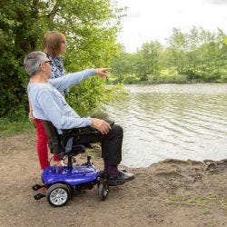 man using powerchair by a lake