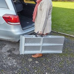 woman carrying Aerofold ramp to a car