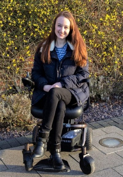 Pippa Stacey sitting in her electric wheelchair web