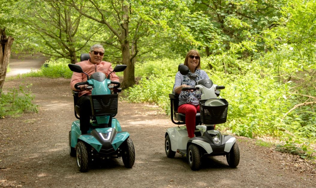 couple riding mobility scooters in woodland park