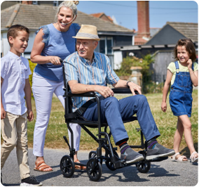 man with family, being pushed in a wheelchair
