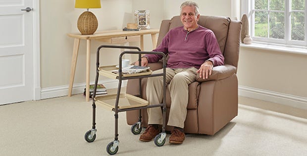 Man sat on chair with a Homehelp Trolley