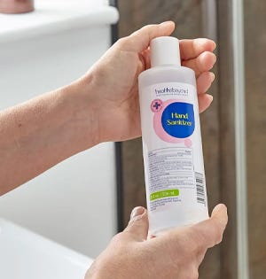 person holding and using hand sanitiser