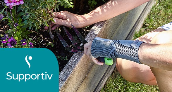 woman in garden digging whilst using hand support