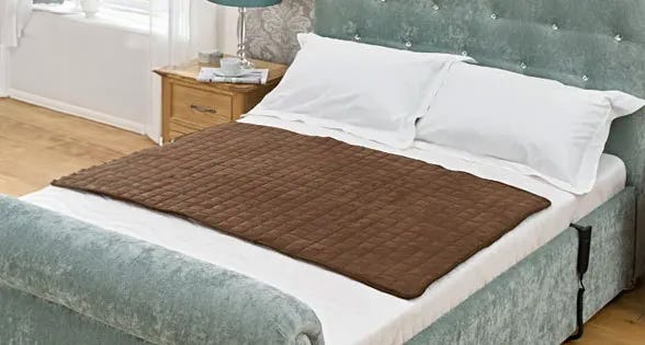 Woman reading book under electric heated blanket