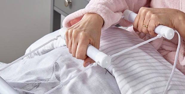 woman pulling herself up with a bed ladder
