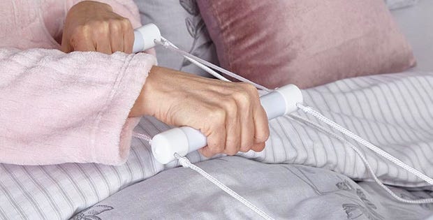 woman pulling herself up with a bed support ladder