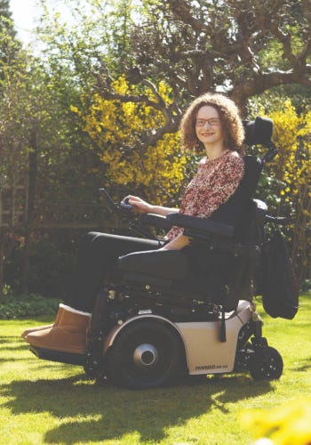 Hannah Deakin sitting on her Powerchair on her lawn