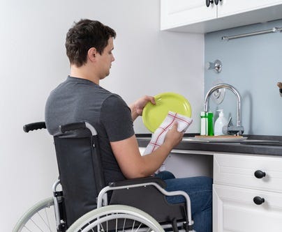 man in wheelchair at an accessible kitchen sink 