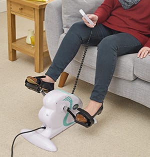 woman sat on sofa while using a pedal machine
