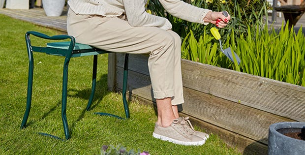 woman sat on a garden bench to do some gardening