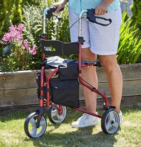 Man pushing a red tri-walker over lawn