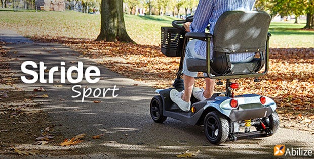 woman riding a mobility scooter in autumn setting in a park