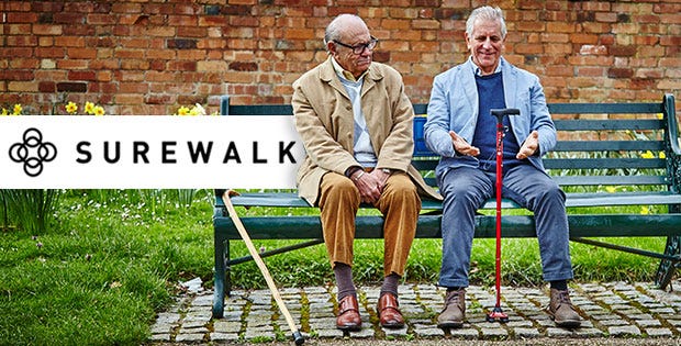 two men with walking sticks sitting on a bench 