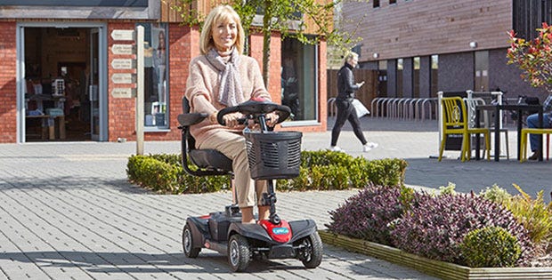 woman riding the Zoom mobility scooter in a retail park